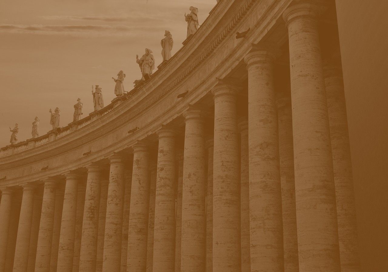 Sepia view of a curved stone colonnade topped with statues, at Saint Peter's Square.